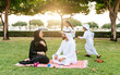 © oneinchpunch - Arabian family in traditional dress smiling together on a picnic blanket in a sunny green park, parents and children enjoying leisure, bonding and relaxation outdoors