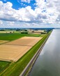© Seglek - Aerial view of a vast agricultural landscape with fields and a large body of water