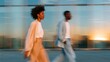 © World of AI - Two office workers in casual attire walking briskly outside a modern building during sunset, with reflections on glass windows creating a dynamic visual effect