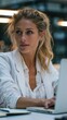 © Studio Zenith - Femme blonde travaillant sur ordinateur portable dans un bureau moderne