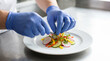 © AIMIN - World Food Safety Day blue gloves plating vegetables presentation professional kitchen hygiene safe food handling culinary arrangement artistic cooking quality standard