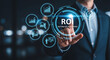 © MstSageda - Businessman touching virtual ROI button with financial growth and data analysis icons