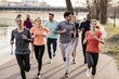 © Juan - Young adults jogging together in urban riverside park