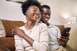 © peopleimages.com - Happy, black couple and laughing with phone in home for funny joke, social media or post. Man, woman or browsing with smile on mobile smartphone for app subscription, comedy network or humor in house