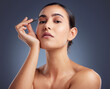 © peopleimages.com - Tweezer, beauty and portrait of woman in studio for self care, grooming and hair removal for eyebrows. Skincare, maintenance and person with tools for shape, epilation and hygiene on gray background