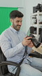 © Krakenimages.com - Man checking camera and smiling while seated in a studio with a green screen and shelving; calm concentration.