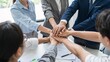 © Studicon - Diverse team of professionals demonstrates unity with hands stacked in a show of solidarity