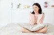 © TrieuMai - Smiling young woman relaxing on bed at home