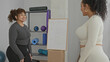© Krakenimages.com - Woman shaking hands with friend by whiteboard and yoga props, foam rollers and exercise balls in fitness studio; friendship support joy.