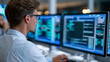 © Nataliya - Rear view of an expert analyzing cybersecurity and business intelligence on a large monitor leveraging advanced analytics, analytics for security concept, large screen monitoring