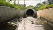 © Phuwadon - A close-up view of polluted water flowing from a concrete drain, highlighting environmental issues and waste management challenges.
