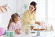 © New Africa - Birthday celebration. Mother and daughter preparing candy bar for festive party at home