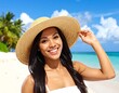 © Nasauki - A woman in a wide-brimmed hat smiles on a beach