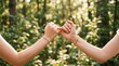 © Touben - International friendship day two friends pinky promise in lush green forest