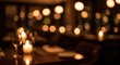 © joharia - Warm golden bokeh lights from candles in a dimly lit romantic restaurant at night.
