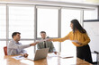 © fizkes - Smiling businesswoman handing out documents to clients or colleagues, sharing materials for reviewing infographics, statistics, and business data results during office corporate discussion meeting