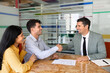 © fizkes - Couple shake hands with bank manager after signing contract in office, confirming agreement, completing financial transaction. Mortgage approval, banking service, partnership, successful deal closure