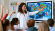 © Mrammon - Teacher classroom student child digital screen map geography education interactive teacher guiding diverse student bright classroom using digital screen world map for engaging geography lesson