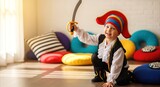 Joyful young boy in pirate costume holding toy sword, playing in a bright, colorful room with cushions and sunlight