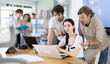 © JackF - Group of coworkers gathered at one laptop and discuss working issues. While discussing their work, young scientists look at laptop monitor and discuss joint project.