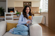 © Jelena - Woman enjoying coffee while working on laptop at home