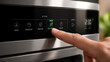© Lasan - Close up of a person’s finger pressing an Eco-Mode touch button on a modern smart kitchen appliance for energy saving