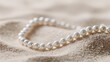 © phianguma - Elegant Pearl Necklace on Soft Sandy Background for Elegant Displays
