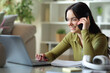 © Antonioguillem - Happy young student talking on phone e-learning at home