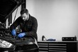 © Leo Rohmann - Automotive repair workflow with mechanic servicing car engine in professional workshop