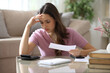© PheelingsMedia - Worried woman complaining doing accounting at home