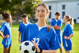 Portrait of focused soccer female player holding football ball