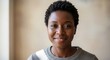 © moon - Smiling Young Black Woman Looking at Camera in Bright Indoor Setting