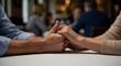 © improvee design - couples hands clasped together on a table in a dimly lit restaurant, symbolizing connection and intimacy.