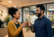 © IZZUL - Happy diverse colleagues clinking coffee cups in modern office