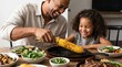 © Dalijhoe - Happy father and daughter eating grilled corn at a table for dinner