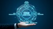 © Usman - Edge computing concept with a hand holding a glowing blue circle with related terms