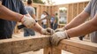 © Aurora Aesthetics - volunteer hands building wooden frame house habitat humanity construction charity nonprofit help hands hammering wooden frame for habitat humanity home build for housing charity nonprofit visuals