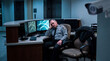 © Christelle - Sleeping Security Guard Sitting at Desktop Monitor in Surveillance Room