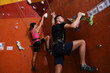 © New Africa - Athletic man and woman climbing wall in gym