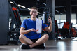 © New Africa - Happy young man with jar of protein powder in gym