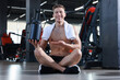 © New Africa - Happy young man with jar of protein powder in gym