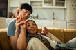 © Marko Geber - Two women cuddling on a sofa at home