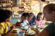 © Davor - Parents and children eating breakfast in a home kitchen
