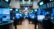 © Ulul Albab LM Putra - Blurred view of a busy stock exchange trading floor with multiple screens displaying financial data and people working.
