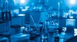 © Ulul Albab LM Putra - Laboratory equipment including pipettes, beakers, flasks, and test tubes arranged on a dark table in a blue-toned research environment with blurred background lights.