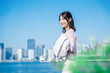 © maroke - ジャケットを脱いで外を歩くビジネスウーマン