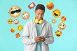 © Pixel-Shot - Teenage African-American boy with headphones and mobile phone on color background