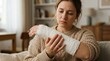 © Gophotograph - Distressed young woman with a fractured right arm in a white cast massaging her injury.