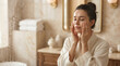 © Valentina Sorokina - Woman applying skincare cream in a luxury bathroom during her morning beauty routine. Woman taking time for her daily skincare ritual in an elegant bathroom at home. Modern beauty care, healthy skin m