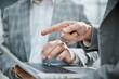 © ASDF - Businessman points at laptop screen with focused gesture